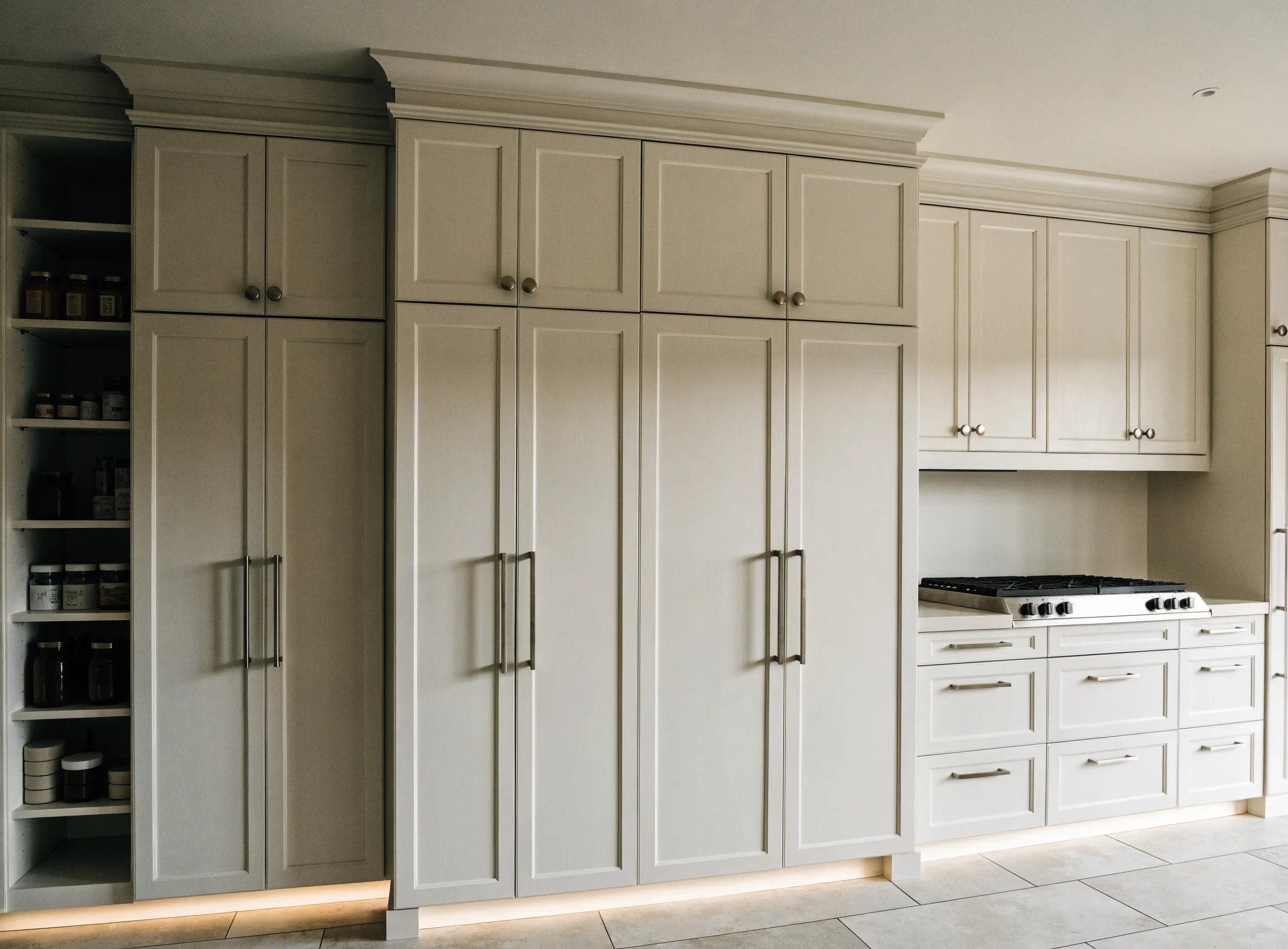 Floor-to-ceiling custom cabinetry in a Boca Raton kitchen, with a tall pantry beside a panel-front refrigerator